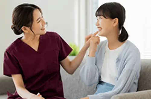 女性歯科医と笑顔でコミュニケーショをとっている女の子の画像