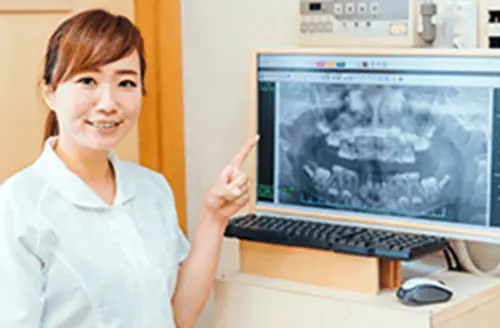 レントゲンを指差している女性歯科医の画像