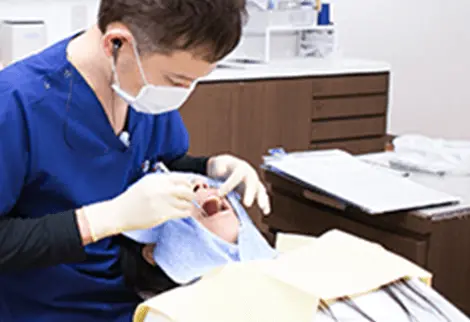男性歯科医が歯の治療をしている画像
