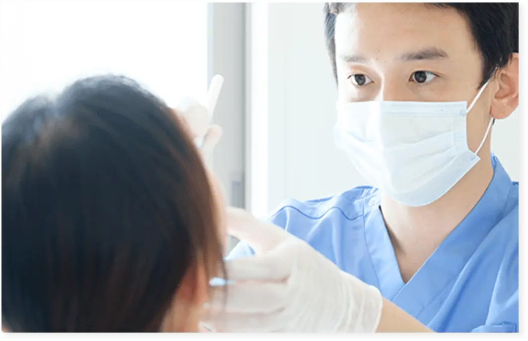 男性歯科医が歯の検査をしている画像