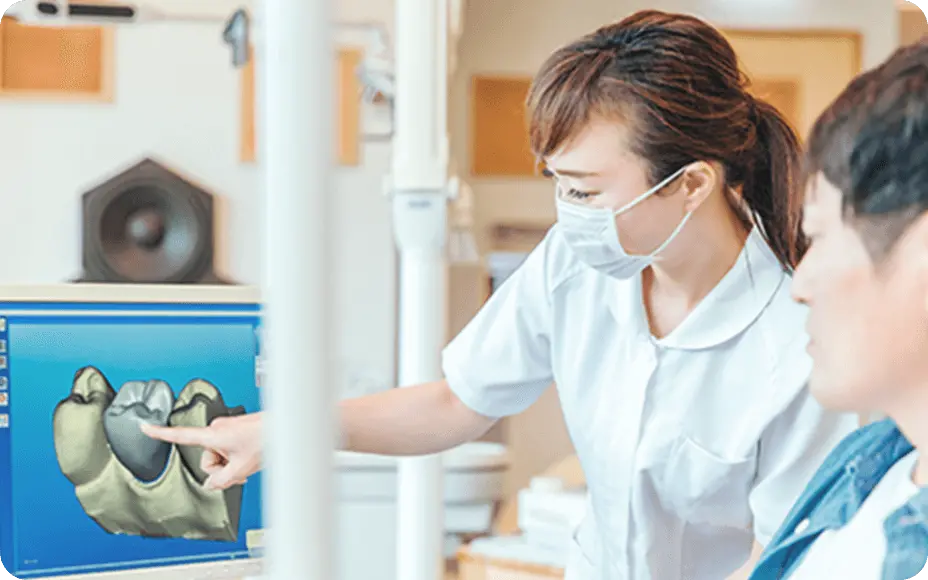 歯科用CTの機械を使って患者さんに説明する女性歯科医の画像