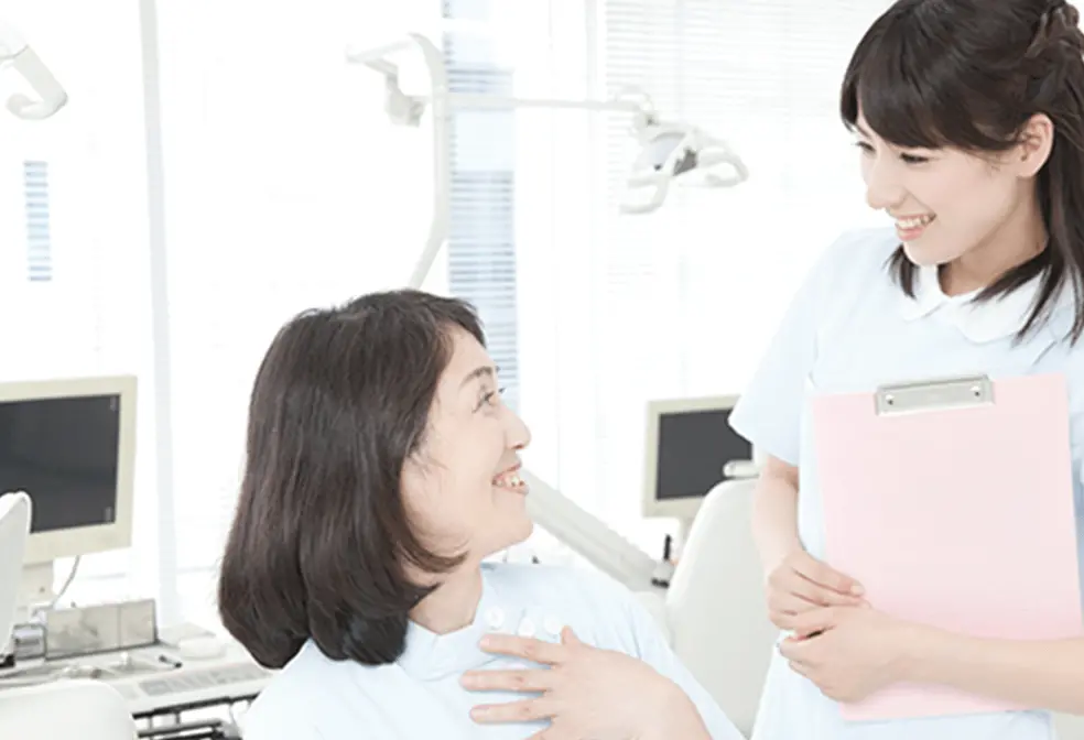 笑顔で患者さんとコミュニケーションを取る女性歯科医の画像